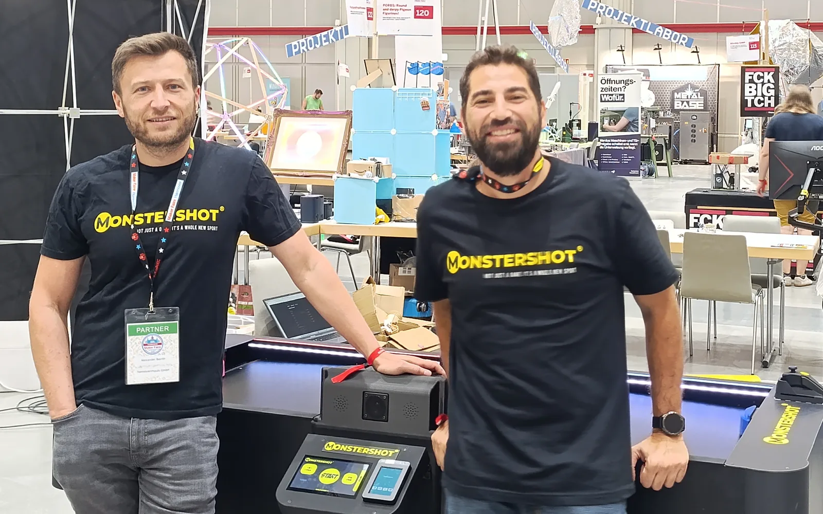 Die Monstershot®-Gründer Maan und Alexander am Spieltisch auf einer Messe