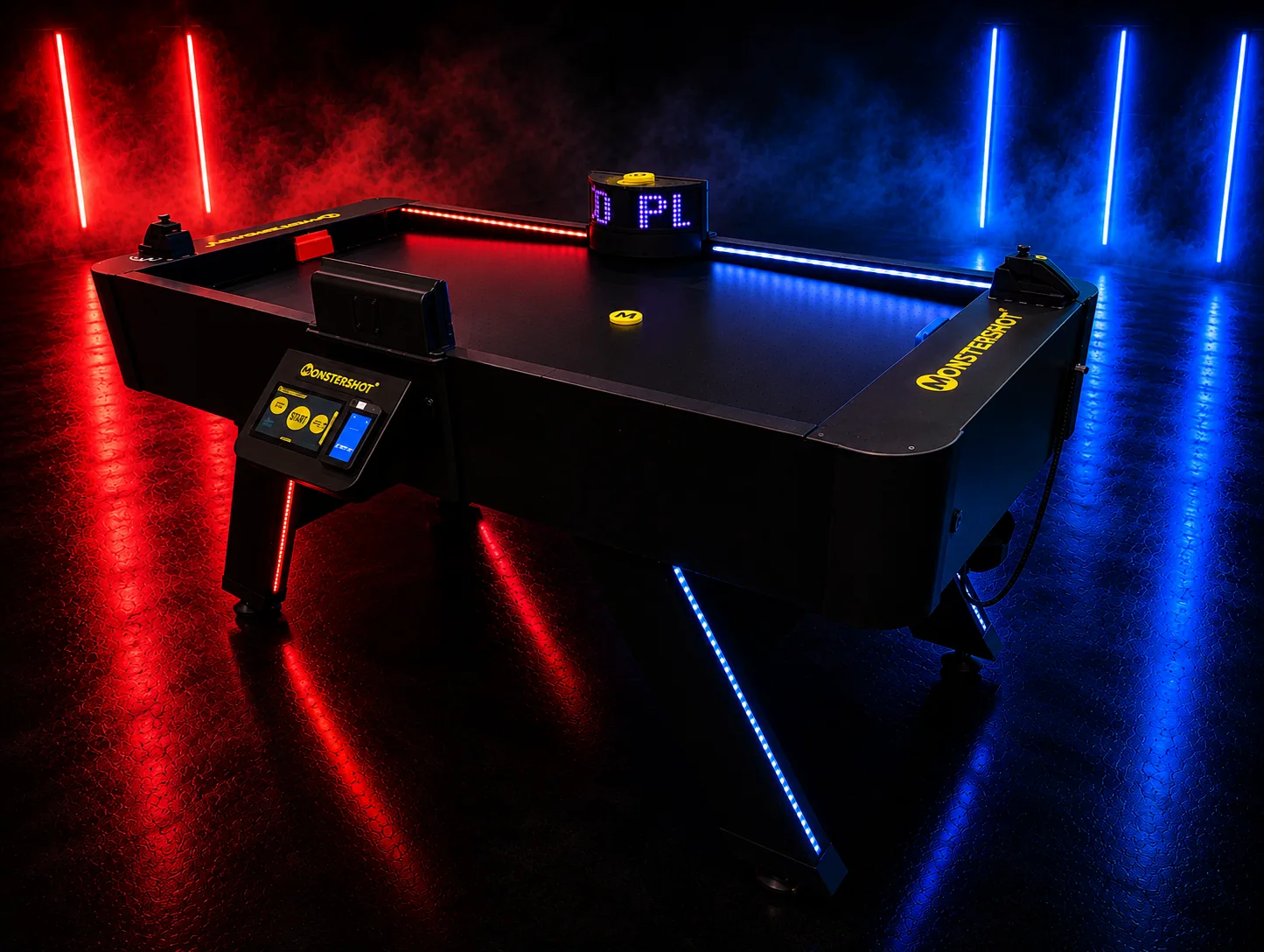 Der Monstershot®-Spieltisch in dunklem Raum, eine Tischhälfte rot und eine blau beleuchtet, mit gelbem Puck, LED-Anzeige und Touchscreen