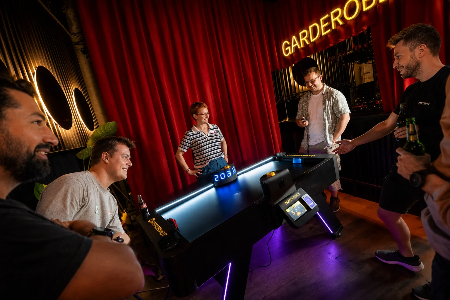 Gäste spielen Monstershot® in einer Bar mit Getränken am Tisch