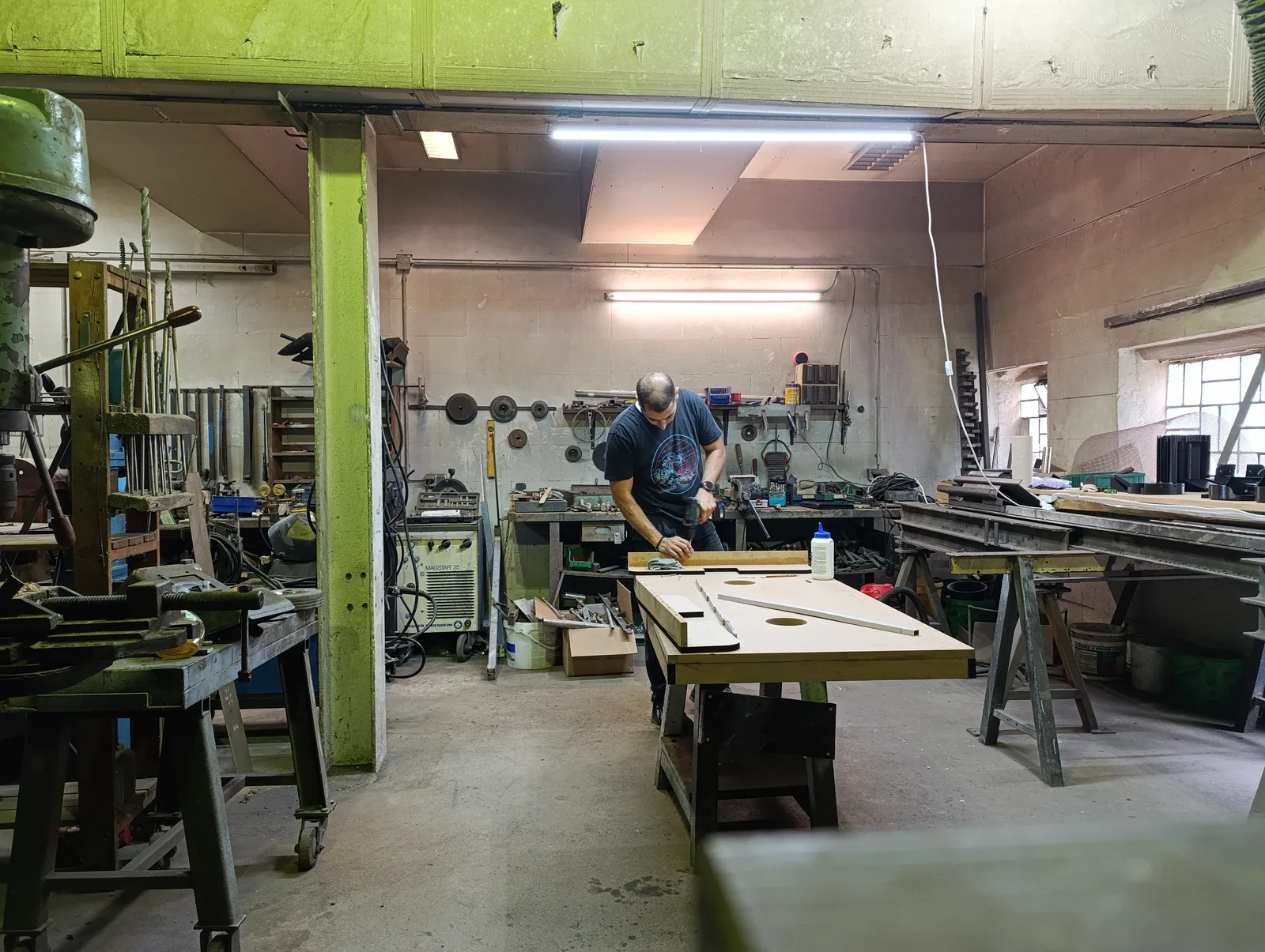 Blick in die Monstershot®-Werkstatt: Spielfeldplatten werden gebohrt, dahinter entstehen weitere Tischgehäuse